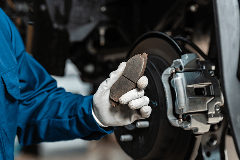 cropped-view-of-mechanic-holding-brake-pad-near-as-2024-11-18-07-25-23-utc